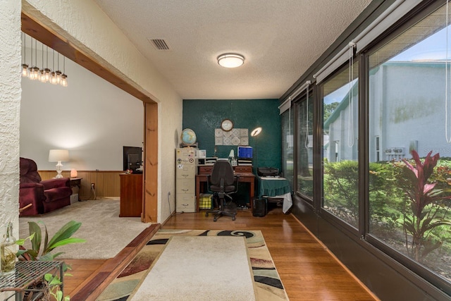 1065 Tartan Dr Unit C, Palm Harbor, FL 34684 - home office featuring a textured ceiling, a wainscoted wall, wood finished floors, and a textured wall