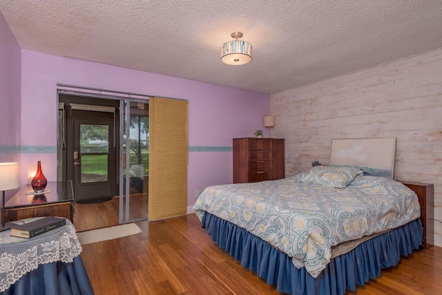 1065 Tartan Dr Unit C, Palm Harbor, FL 34684 - bedroom featuring wood finished floors, a textured ceiling, and access to outside