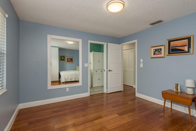1065 Tartan Dr Unit C, Palm Harbor, FL 34684 - bedroom featuring a textured ceiling, wood finished floors, and baseboards