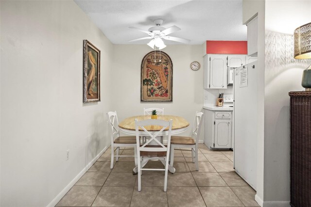 600 71st Ave Unit 18, St Pete Beach, FL 33706 - dining space with a ceiling fan, light tile patterned floors, and baseboards