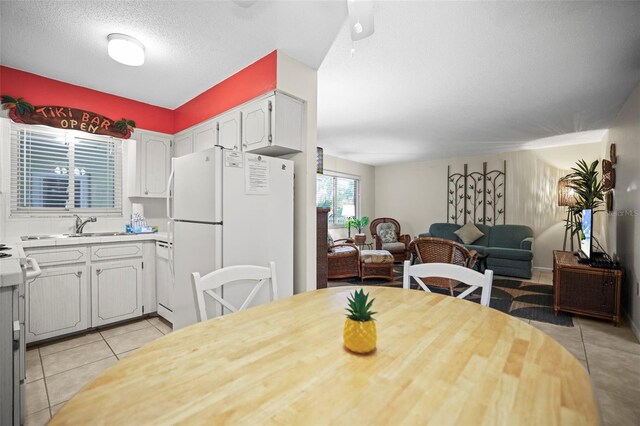 600 71st Ave Unit 18, St Pete Beach, FL 33706 - dining area featuring light tile patterned flooring and a textured ceiling