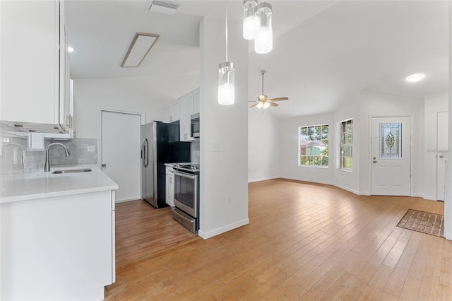 2313 Palm Ave, Seffner, FL 33584 - kitchen with stainless steel appliances, lofted ceiling, a sink, a ceiling fan, and white cabinets