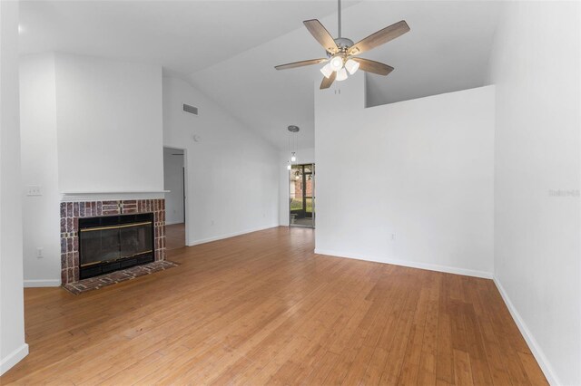 2313 Palm Ave, Seffner, FL 33584 - unfurnished living room featuring ceiling fan, wood finished floors, high vaulted ceiling, a tile fireplace, and baseboards