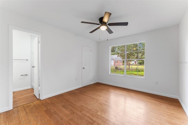 2313 Palm Ave, Seffner, FL 33584 - unfurnished bedroom featuring light wood-style floors, baseboards, a ceiling fan, and ensuite bath