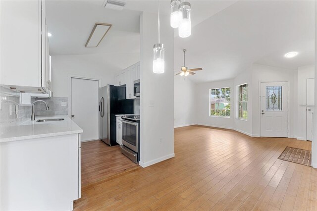 2313 Palm Ave, Seffner, FL 33584 - kitchen with stainless steel appliances, lofted ceiling, ceiling fan, white cabinets, and decorative backsplash