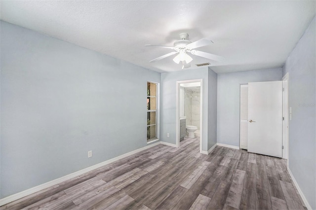 2770 Keats Ter Unit C, Palm Harbor, FL 34684 - unfurnished bedroom featuring wood finished floors, baseboards, ensuite bath, and a ceiling fan