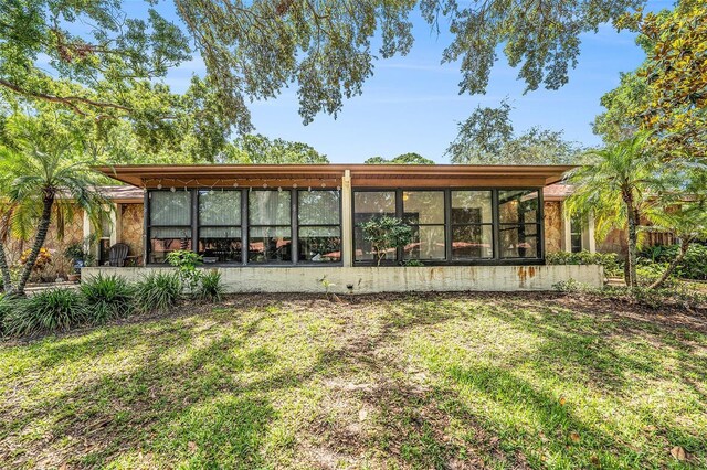 2770 Keats Ter Unit C, Palm Harbor, FL 34684 - rear view of property featuring a lawn and a sunroom