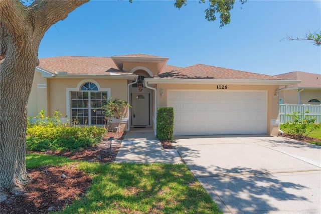 1126 Haley Ln, Dunedin, FL 34698 - view of front of home featuring stucco siding, driveway, and an attached garage