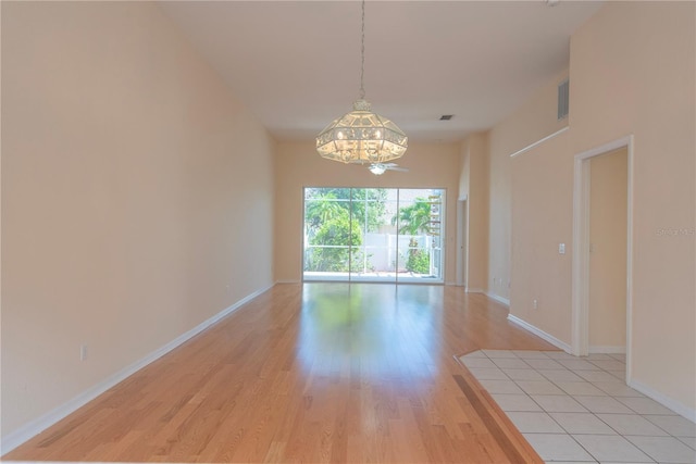 1126 Haley Ln, Dunedin, FL 34698 - spare room featuring light wood-style floors, baseboards, and a chandelier