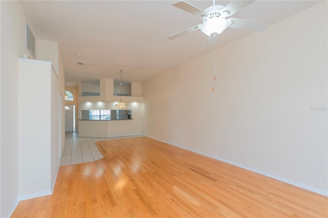 1126 Haley Ln, Dunedin, FL 34698 - unfurnished living room with light wood-style flooring, ceiling fan, and baseboards