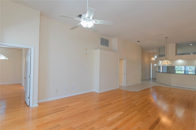 1126 Haley Ln, Dunedin, FL 34698 - unfurnished living room featuring light wood-style flooring, a chandelier, ceiling fan, and baseboards