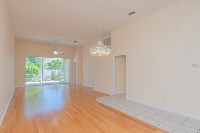 1126 Haley Ln, Dunedin, FL 34698 - spare room with a chandelier, light wood-style floors, baseboards, and ceiling fan