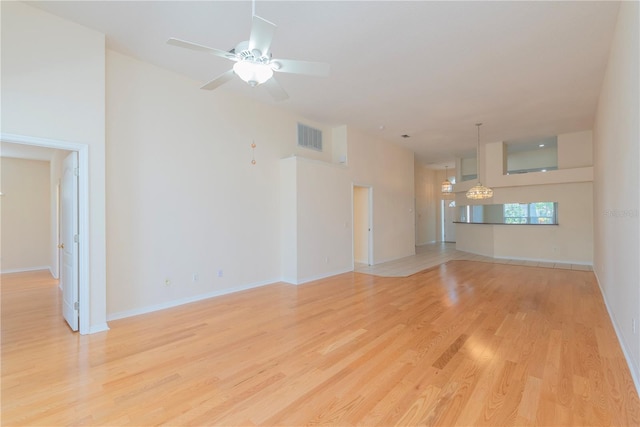 1126 Haley Ln, Dunedin, FL 34698 - unfurnished living room with light wood-style floors, ceiling fan, baseboards, and a chandelier