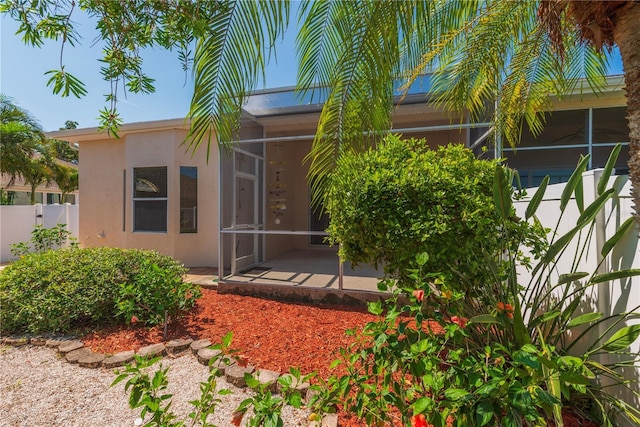 1126 Haley Ln, Dunedin, FL 34698 - rear view of house featuring a sunroom and stucco siding