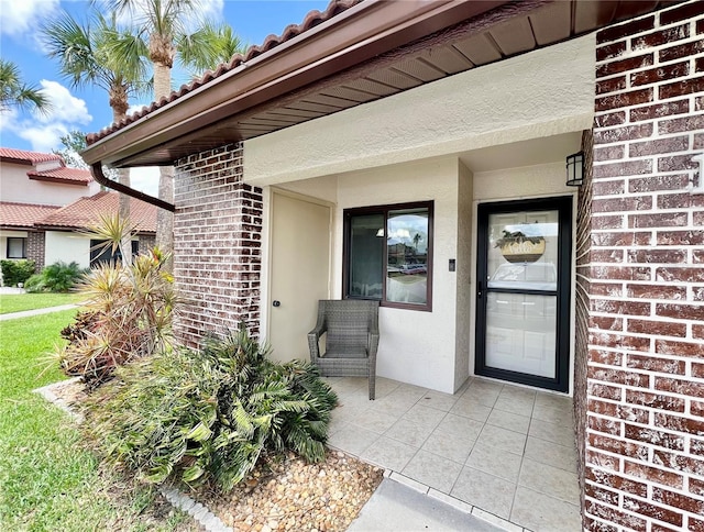 7360 Ulmerton Rd Unit 16A, Largo, FL 33771 - view of exterior entry with brick siding, stucco siding, and a tiled roof