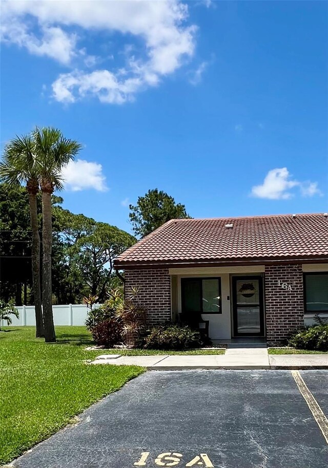 7360 Ulmerton Rd Unit 16A, Largo, FL 33771 - single story home featuring a tiled roof, uncovered parking, and brick siding