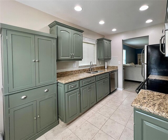7360 Ulmerton Rd Unit 16A, Largo, FL 33771 - kitchen featuring a sink, green cabinetry, stainless steel appliances, recessed lighting, and light tile patterned floors