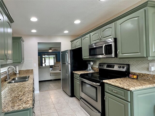 7360 Ulmerton Rd Unit 16A, Largo, FL 33771 - kitchen with appliances with stainless steel finishes, a sink, green cabinets, and recessed lighting