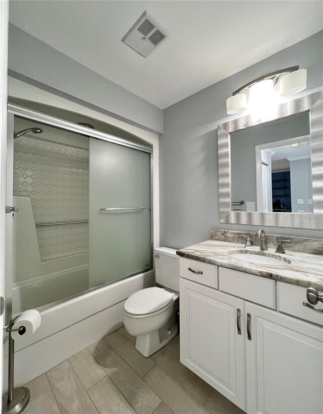 7360 Ulmerton Rd Unit 16A, Largo, FL 33771 - full bathroom featuring vanity, enclosed tub / shower combo, a textured wall, and toilet