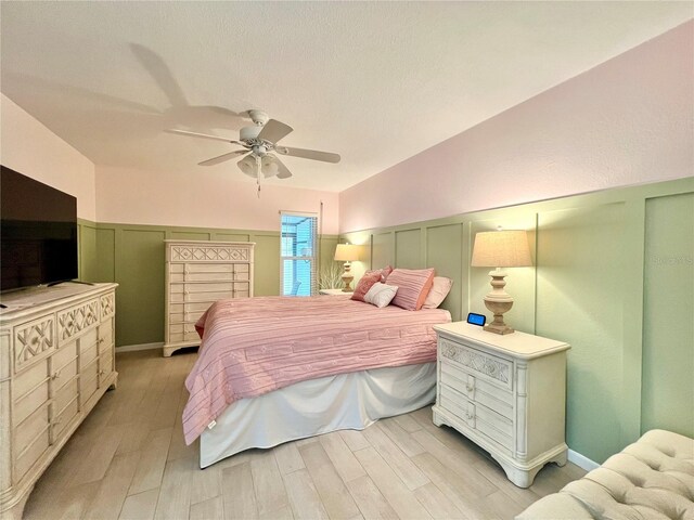7360 Ulmerton Rd Unit 16A, Largo, FL 33771 - bedroom with a decorative wall, wainscoting, light wood-style flooring, and a ceiling fan