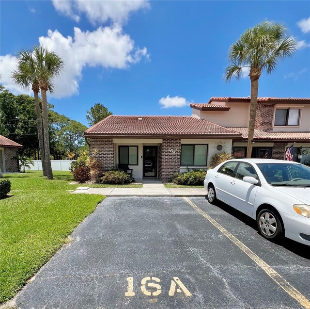 7360 Ulmerton Rd Unit 16A, Largo, FL 33771 - view of front of home with a tile roof, uncovered parking, and stucco siding
