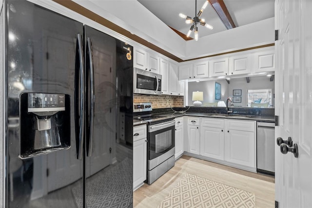 2665 Sequoia Ter Unit 306, Palm Harbor, FL 34683 - kitchen featuring appliances with stainless steel finishes, dark countertops, a sink, and white cabinetry