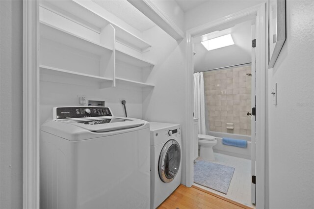 2665 Sequoia Ter Unit 306, Palm Harbor, FL 34683 - clothes washing area with separate washer and dryer, a skylight, and light wood-style flooring