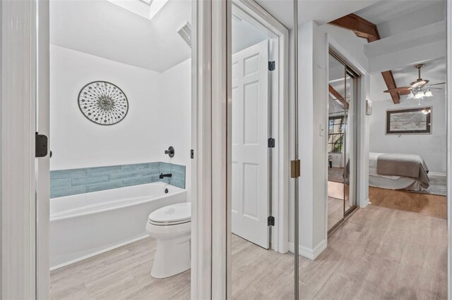 2665 Sequoia Ter Unit 306, Palm Harbor, FL 34683 - full bathroom featuring wood finished floors, toilet, a garden tub, beamed ceiling, and ensuite bath