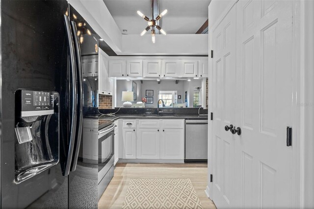 2665 Sequoia Ter Unit 306, Palm Harbor, FL 34683 - kitchen featuring appliances with stainless steel finishes, a sink, dark countertops, and white cabinets