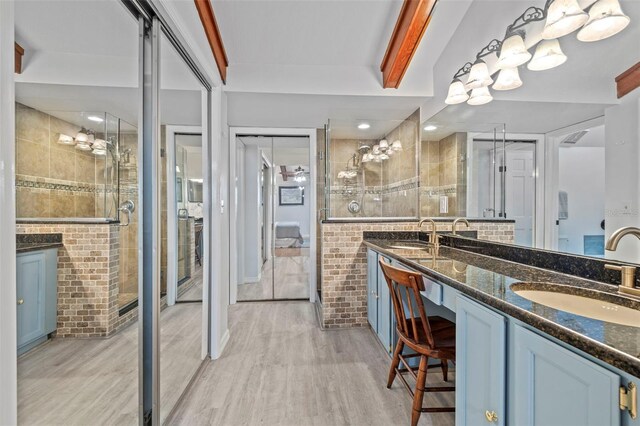 2665 Sequoia Ter Unit 306, Palm Harbor, FL 34683 - bathroom featuring wood finished floors, double vanity, a shower stall, and tile walls