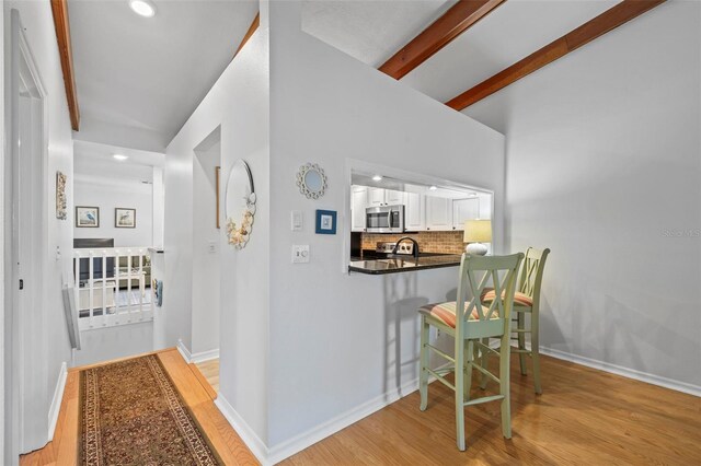 2665 Sequoia Ter Unit 306, Palm Harbor, FL 34683 - hall with light wood-style flooring, baseboards, recessed lighting, and beamed ceiling