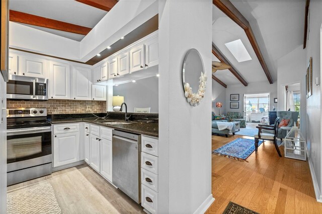 2665 Sequoia Ter Unit 306, Palm Harbor, FL 34683 - kitchen featuring stainless steel appliances, a sink, a skylight, and white cabinetry
