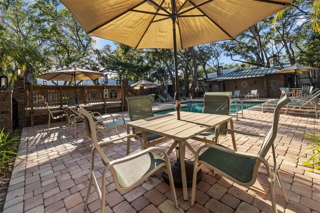2665 Sequoia Ter Unit 306, Palm Harbor, FL 34683 - view of patio / terrace with outdoor dining space, a community pool, a wooden deck, and fence