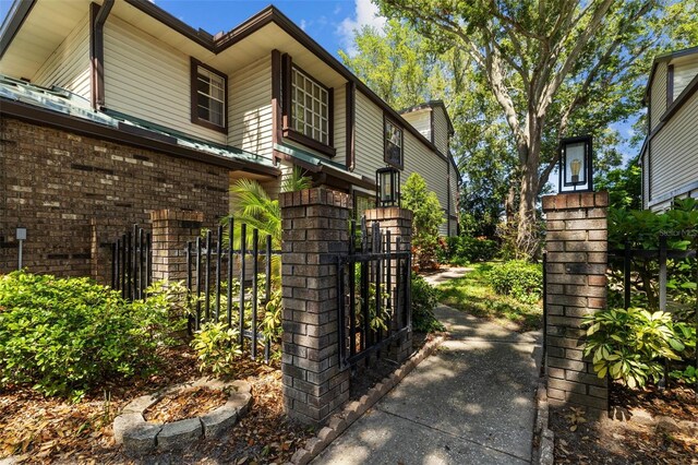 2665 Sequoia Ter Unit 306, Palm Harbor, FL 34683 - view of home's exterior featuring fence, a gate, and brick siding