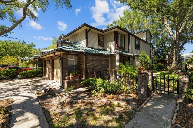 2665 Sequoia Ter Unit 306, Palm Harbor, FL 34683 - view of front of house featuring concrete driveway, brick siding, a garage, fence, and a gate