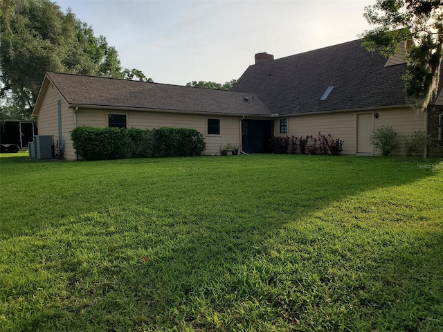 2615 Southern Oaks Pl, Plant City, FL 33566 - back of house with a yard, central AC unit, and a chimney