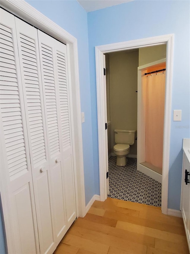 2615 Southern Oaks Pl, Plant City, FL 33566 - bathroom with toilet, wood finished floors, a closet, a shower with shower curtain, and baseboards