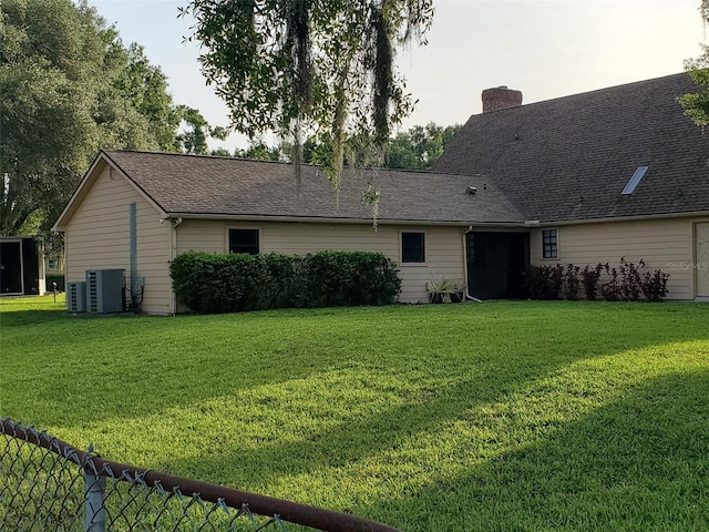 2615 Southern Oaks Pl, Plant City, FL 33566 - rear view of house featuring central air condition unit, a lawn, and a chimney