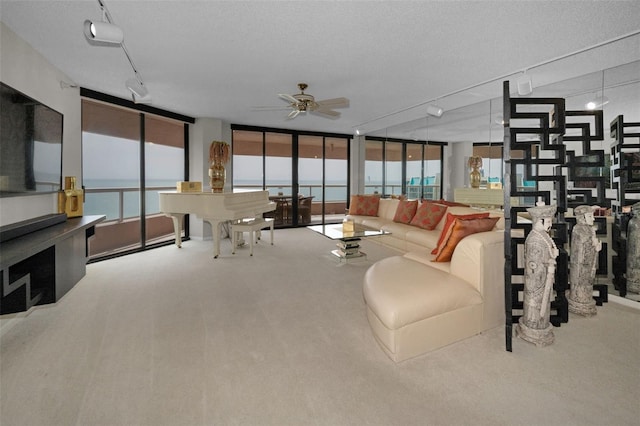 1340 Gulf Blvd Unit 16A, Clearwater Beach, FL 33767 - carpeted living area featuring ceiling fan, floor to ceiling windows, and a textured ceiling
