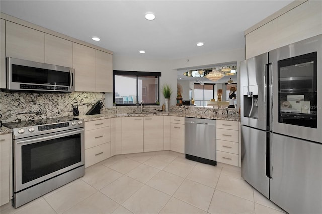 1340 Gulf Blvd Unit 16A, Clearwater Beach, FL 33767 - kitchen featuring appliances with stainless steel finishes, a sink, tasteful backsplash, light stone counters, and recessed lighting