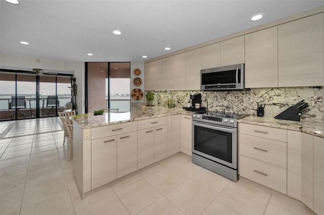 1340 Gulf Blvd Unit 16A, Clearwater Beach, FL 33767 - kitchen featuring appliances with stainless steel finishes, a peninsula, backsplash, modern cabinets, and recessed lighting