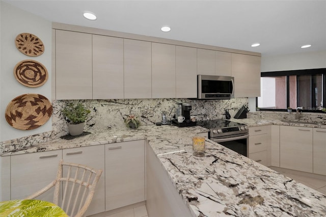 1340 Gulf Blvd Unit 16A, Clearwater Beach, FL 33767 - kitchen featuring stainless steel appliances, a sink, decorative backsplash, light stone countertops, and recessed lighting