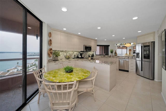 1340 Gulf Blvd Unit 16A, Clearwater Beach, FL 33767 - kitchen featuring stainless steel appliances, tasteful backsplash, light tile patterned floors, recessed lighting, and modern cabinets