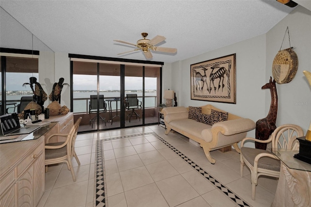 1340 Gulf Blvd Unit 16A, Clearwater Beach, FL 33767 - living area featuring light tile patterned flooring, a ceiling fan, a textured ceiling, and a desk