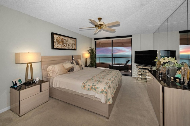 1340 Gulf Blvd Unit 16A, Clearwater Beach, FL 33767 - bedroom featuring light carpet, a textured ceiling, ceiling fan, and a wall of windows