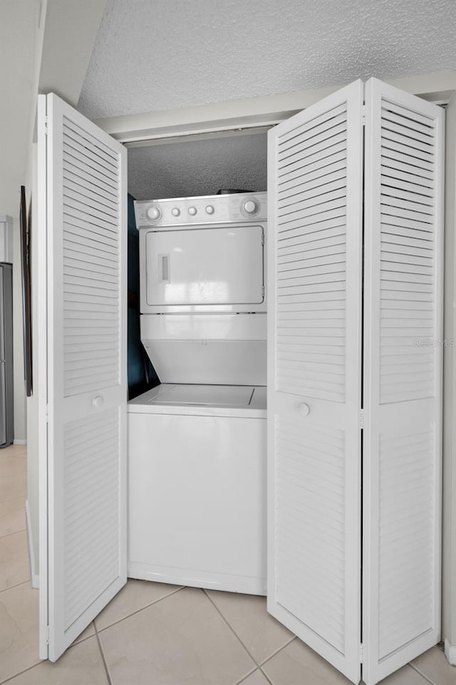 1340 Gulf Blvd Unit 16A, Clearwater Beach, FL 33767 - laundry area featuring stacked washer / dryer and light tile patterned floors