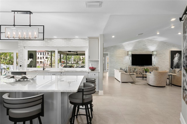 2817 Seabreeze Dr S, Gulfport, FL 33707 - bar with a sink, healthy amount of natural light, vaulted ceiling, light tile patterned floors, and recessed lighting