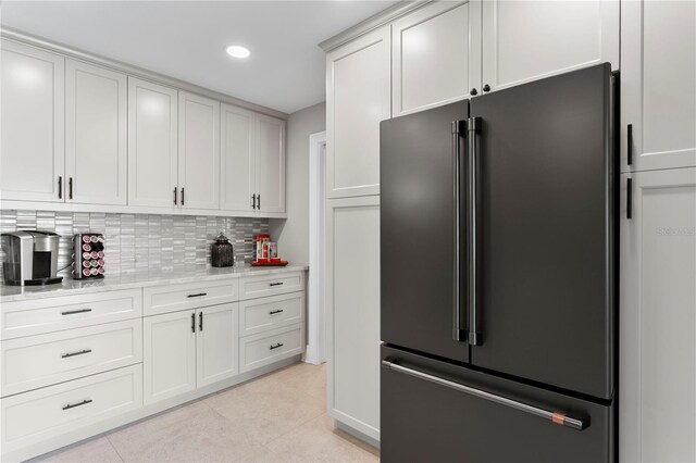 2817 Seabreeze Dr S, Gulfport, FL 33707 - kitchen featuring high end black refrigerator, decorative backsplash, light tile patterned flooring, recessed lighting, and light stone countertops