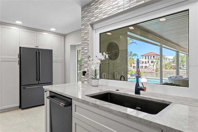 2817 Seabreeze Dr S, Gulfport, FL 33707 - kitchen with high quality fridge, a sink, white cabinets, dishwasher, and light stone counters