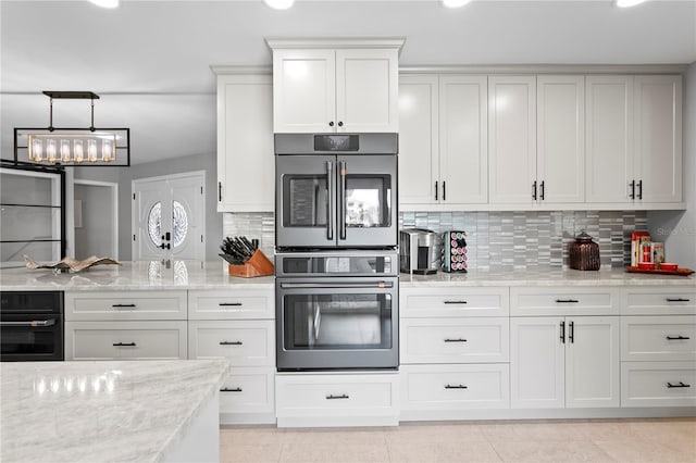 2817 Seabreeze Dr S, Gulfport, FL 33707 - kitchen featuring stainless steel double oven, decorative backsplash, white cabinetry, light stone countertops, and recessed lighting